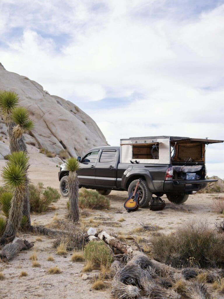 Truck with rooftop camper tent in the desert, customized at a custom car shop for adventure-ready performance
