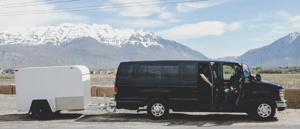 A van with a small trailer at the back of it.